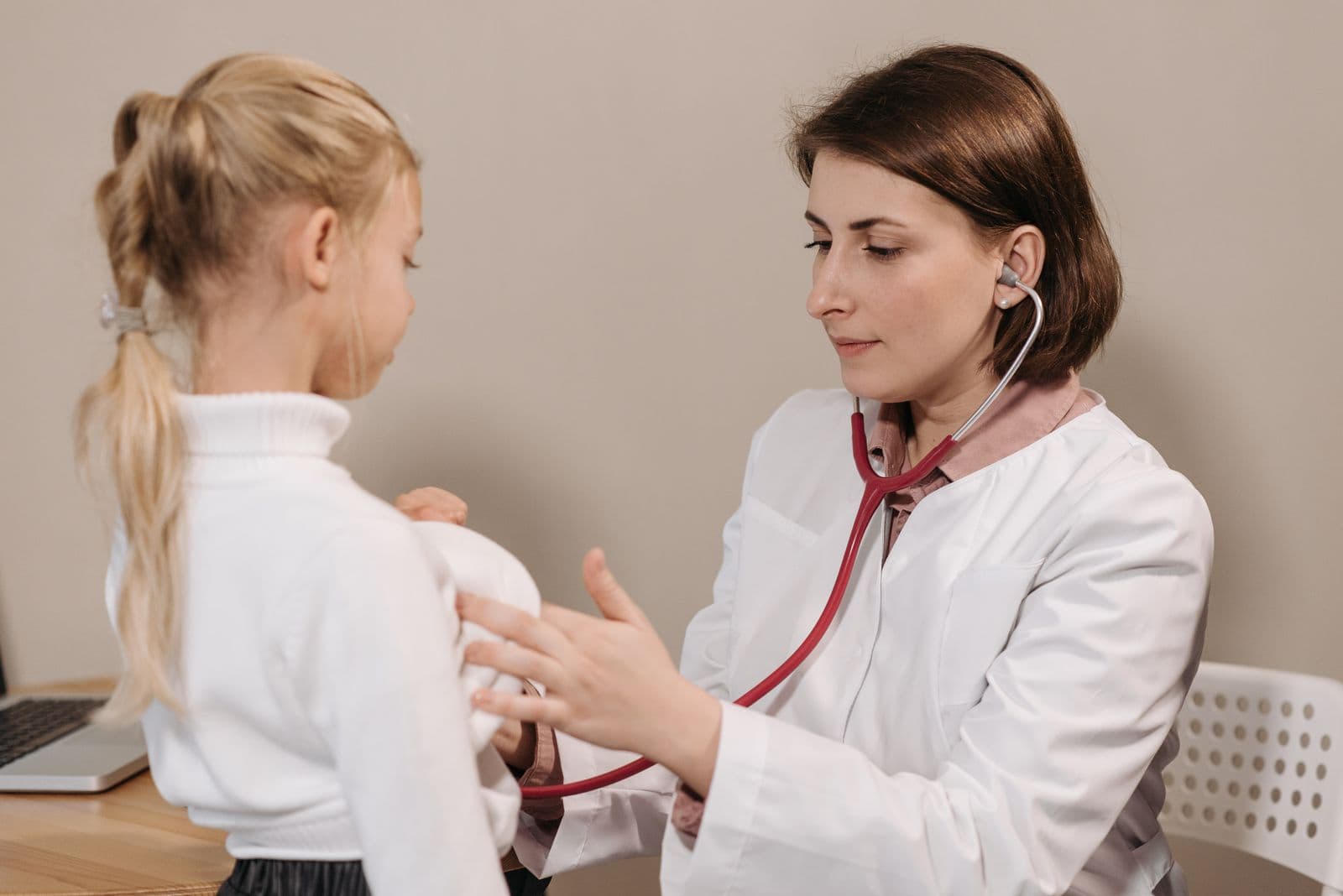 A pediatrician gently examining a young child
